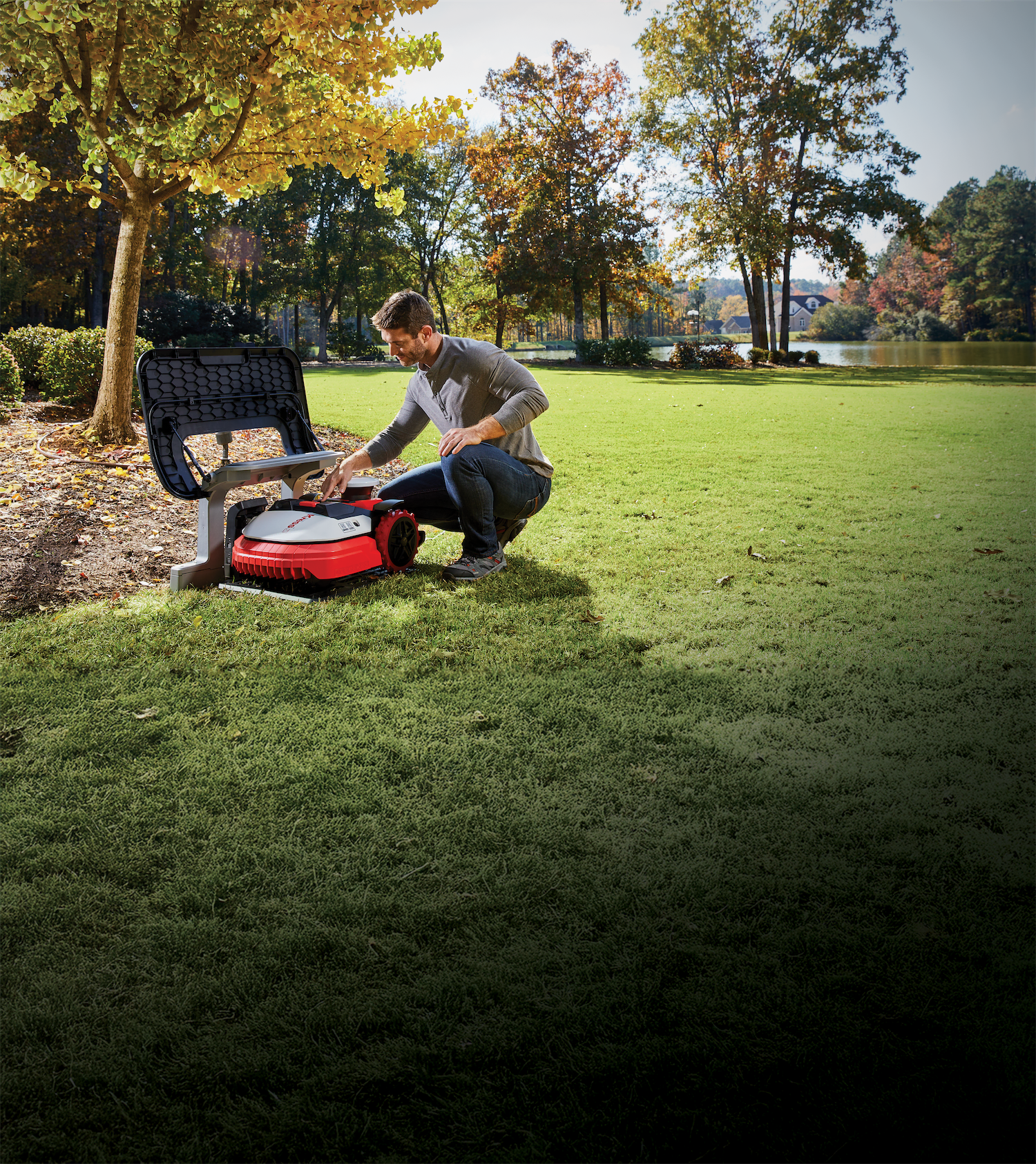 Technician setting up a Kress commercial robotic mower on a lawn
